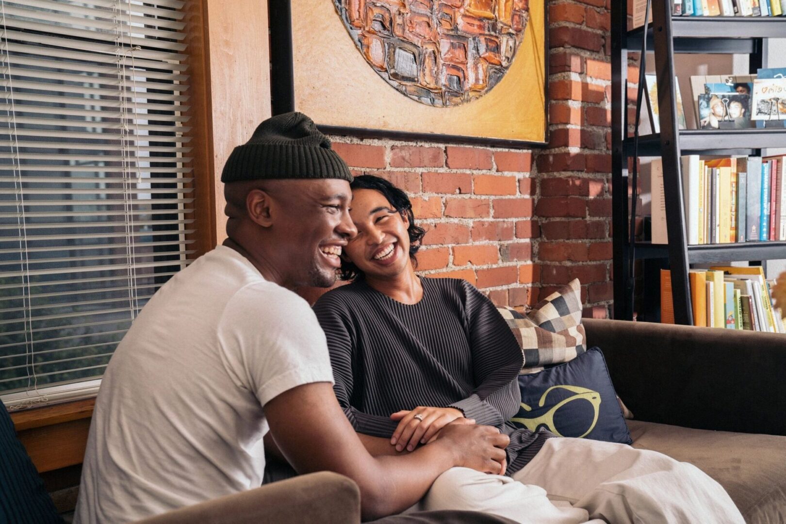 Two men sitting on a couch with their arms around each other.