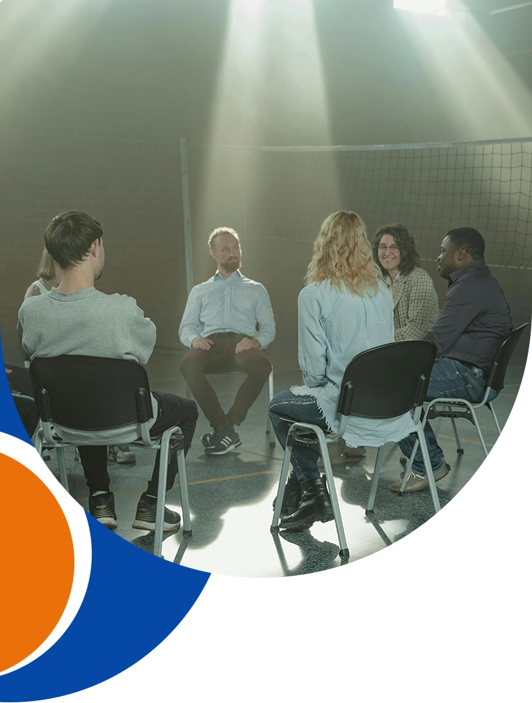 A group of people sitting in chairs and talking.