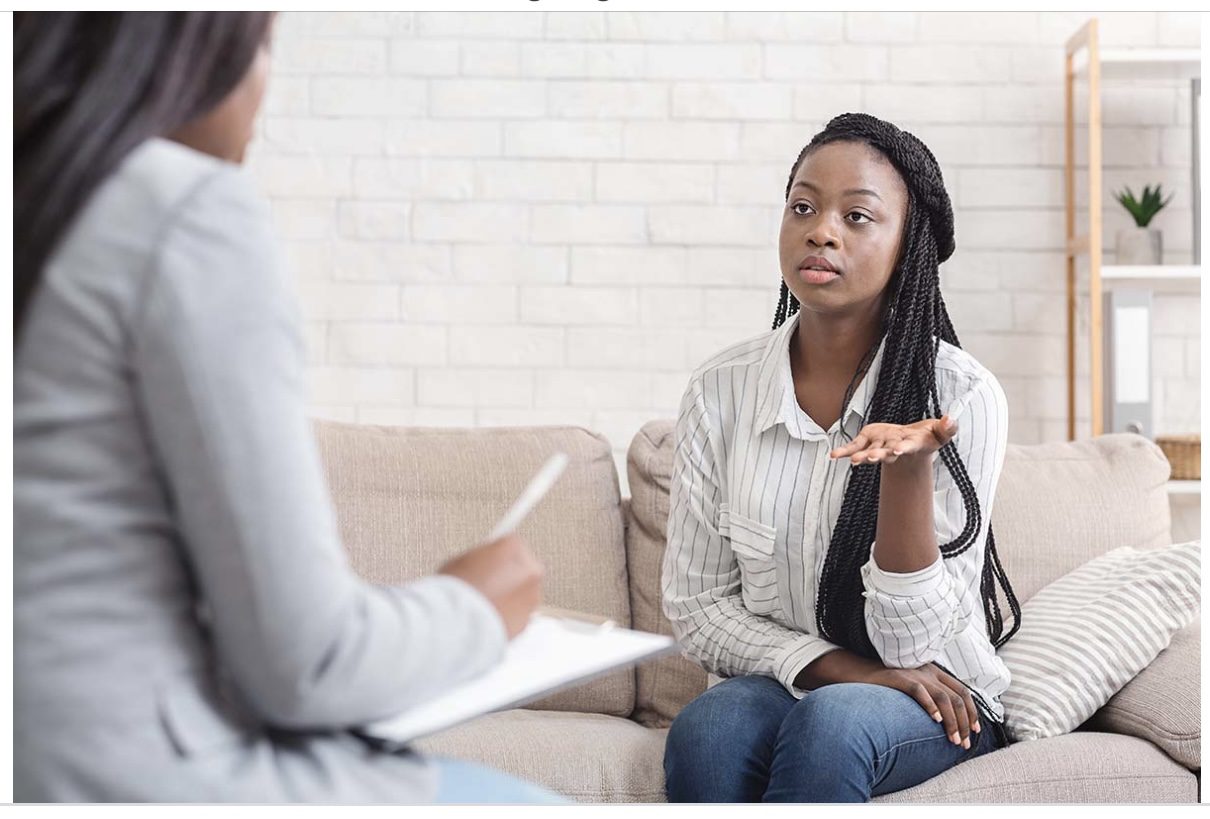 A woman sitting on the couch talking to someone