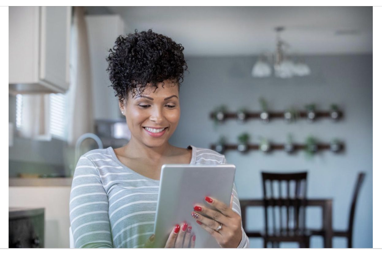 A woman is holding an ipad in her hands.