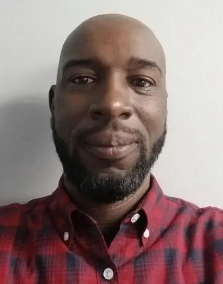 Man with beard wearing plaid shirt.