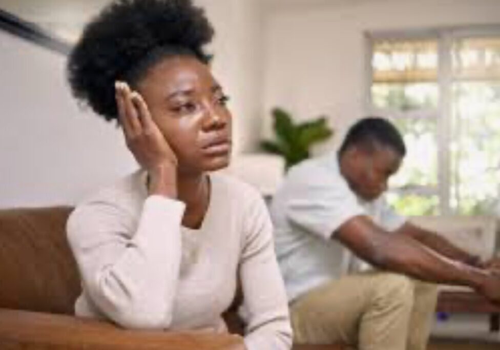 A woman sitting next to another man in a room.